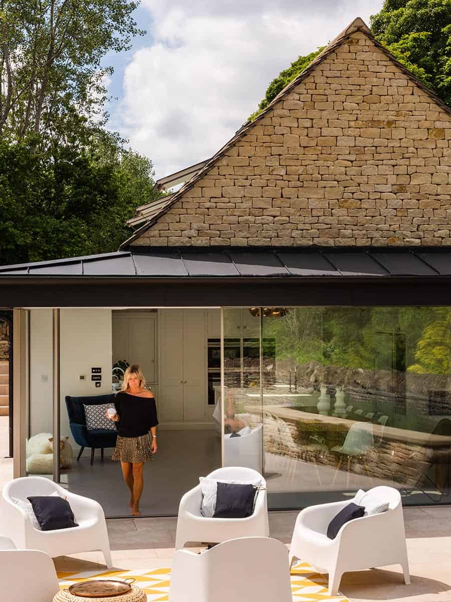 Cambray House Cotswold stone gable with glazed extension, terrace seating and garden, near Stroud